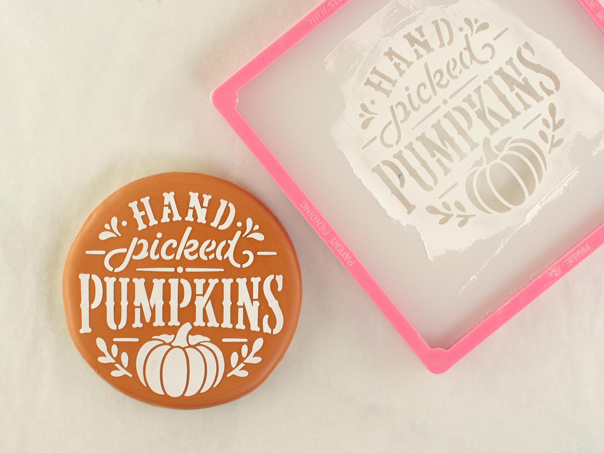 stenciling "hand picked pumpkins" on a cookie using royal icing