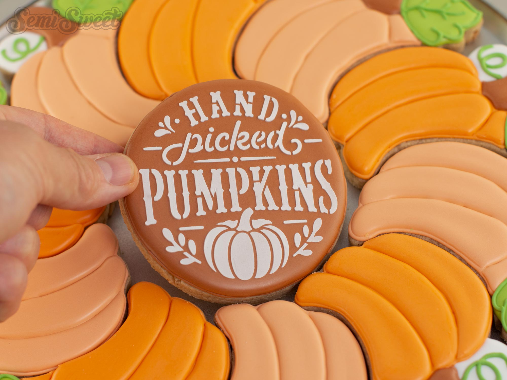 placing the center cookie in the middle of a pumpkin cookie platter