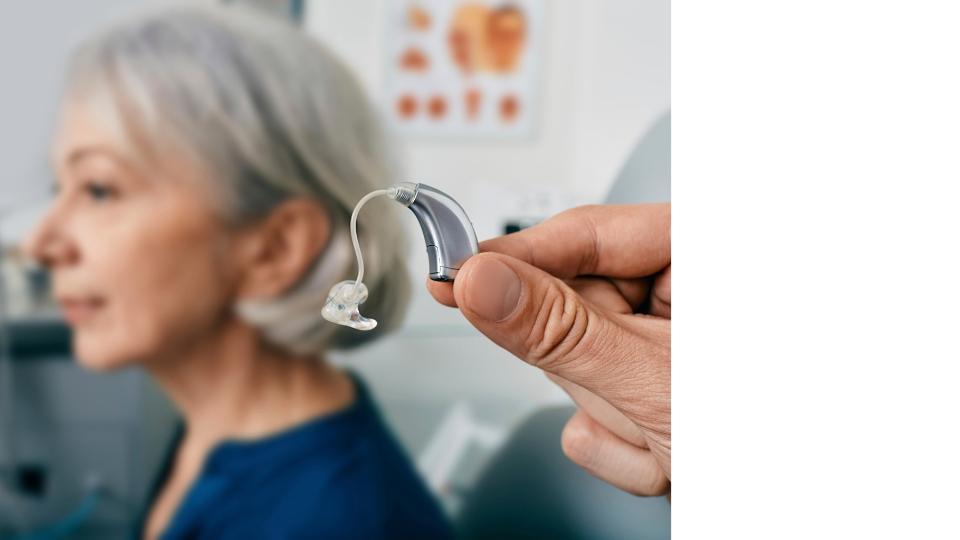 A person holding a hearing aidAI-generated content may be incorrect.