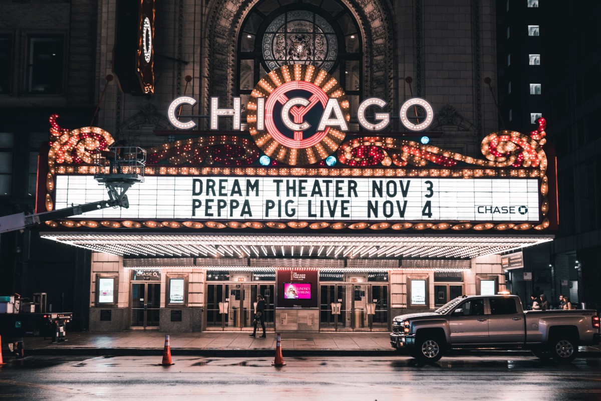 Chicago Theatre marquee illuminated at night with the iconic CHICAGO sign and event listings for Dream Theater and Peppa Pig Live