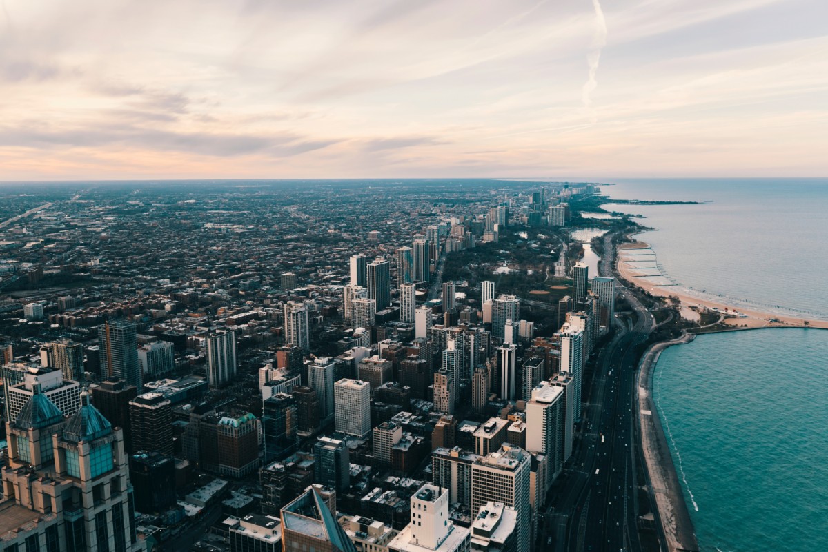 Aerial drone view of the Chicago skyline along Lake Shore Drive with Lake Michigan and beach visible to the right