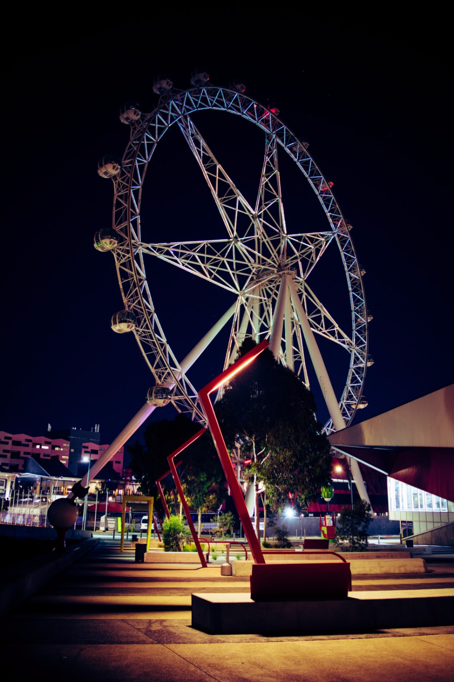 The Melbourne Star observation wheel illuminated at night against a dark sky