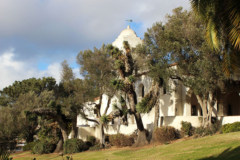 Junípero Serra Museum, a white Spanish mission-style building with a bell tower in Presidio Park San Diego, framed by palm and olive trees