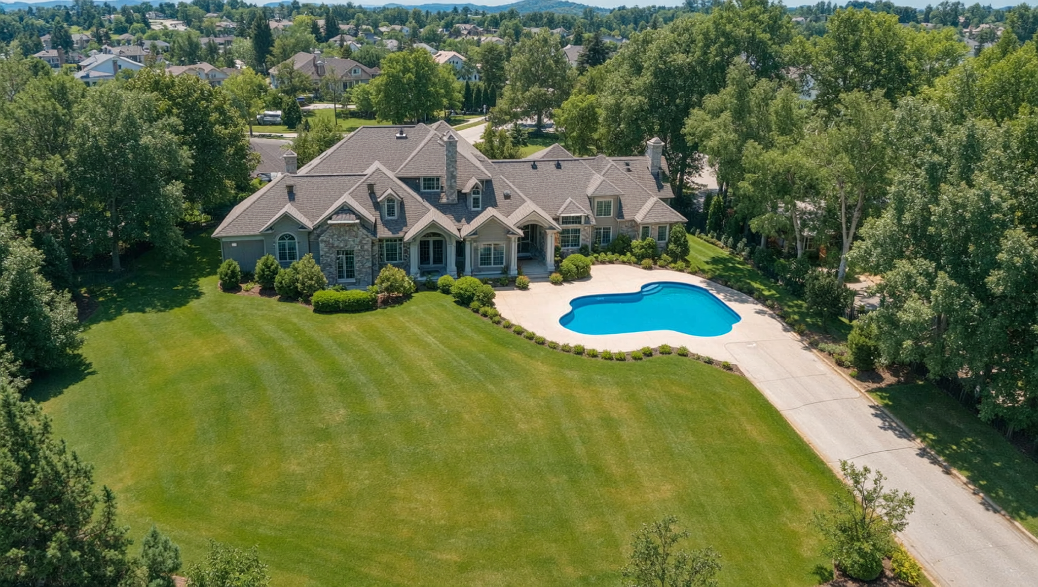 Drone real estate photography showing aerial view of a residential property with pool and landscaping
