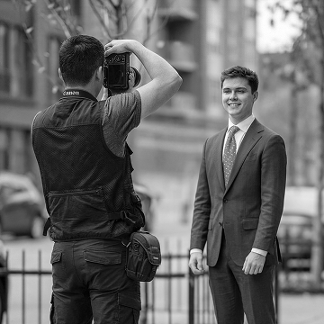 Photographer capturing a man in a suit for a professional portrait on a city street
