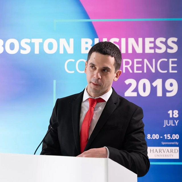 Man delivering a speech at a podium during a professional business conference in Boston.