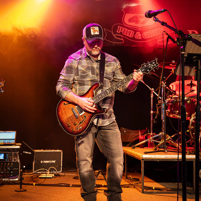 Guitarist performing live on stage at the Route 40 Pub and Grill during a concert.