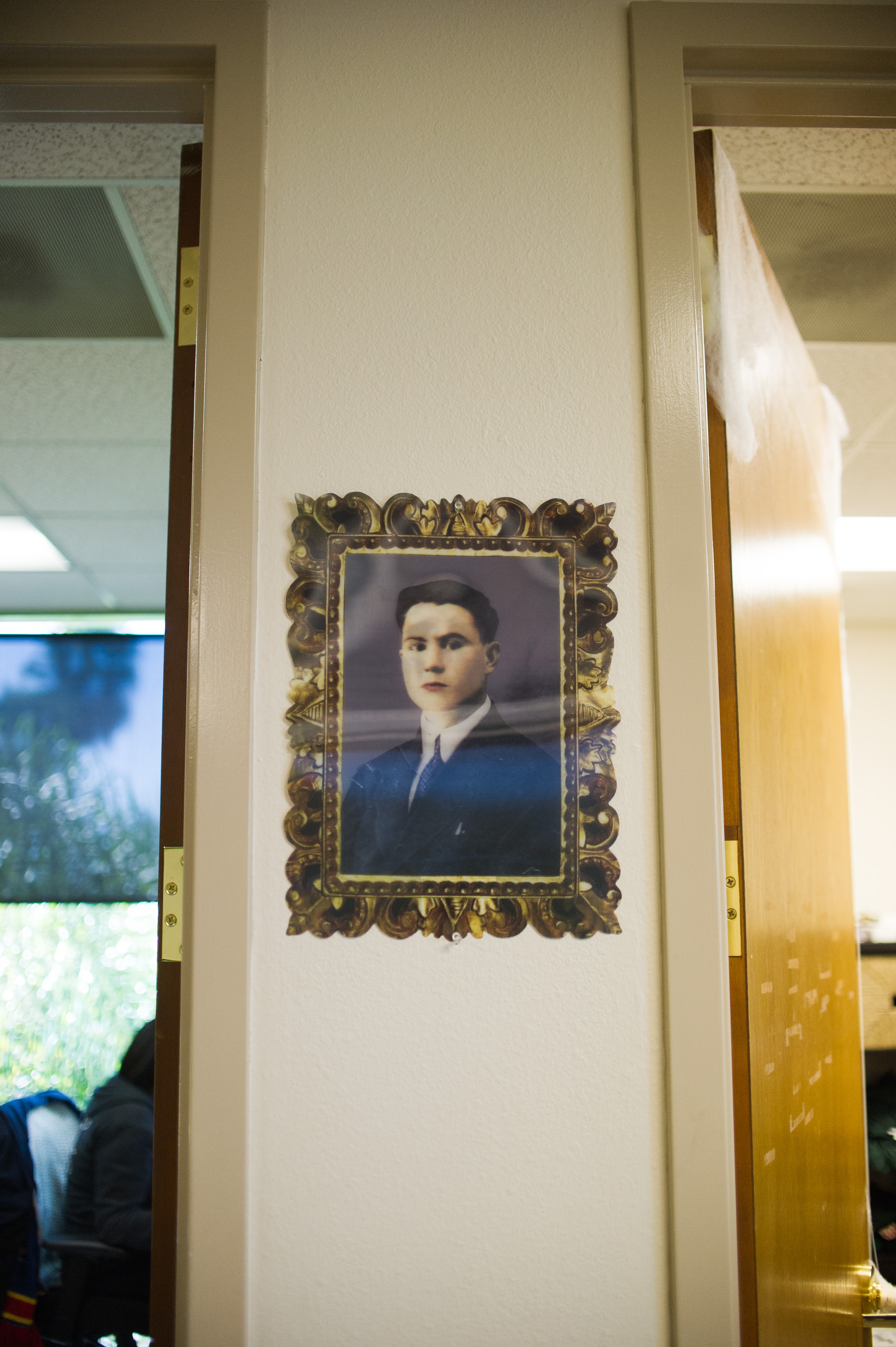 Antique framed portrait of a young man in vintage gold ornate frame hanging on Lawn Love office wall