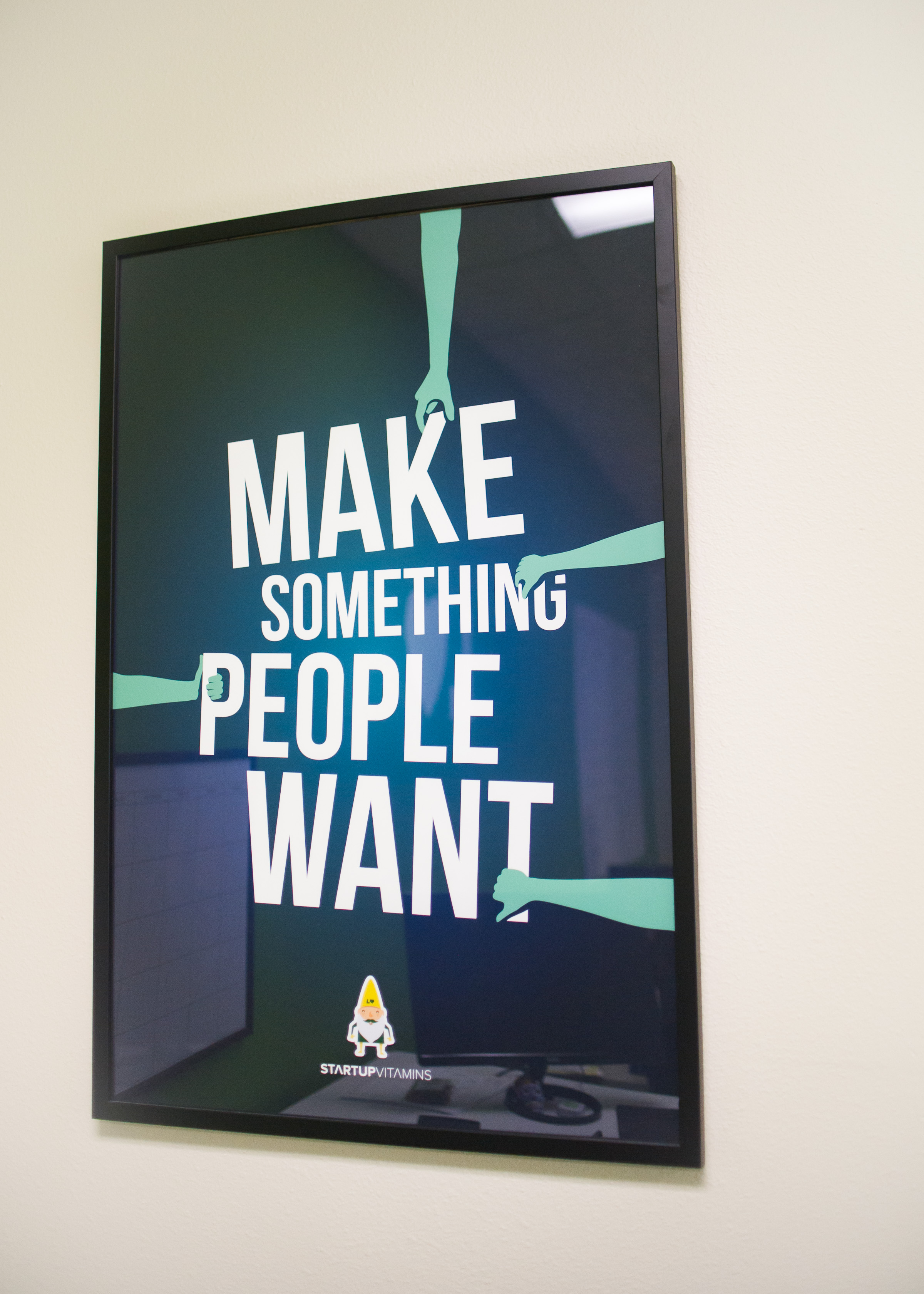 Framed Make Something People Want motivational poster by Startup Vitamins on Lawn Love office wall