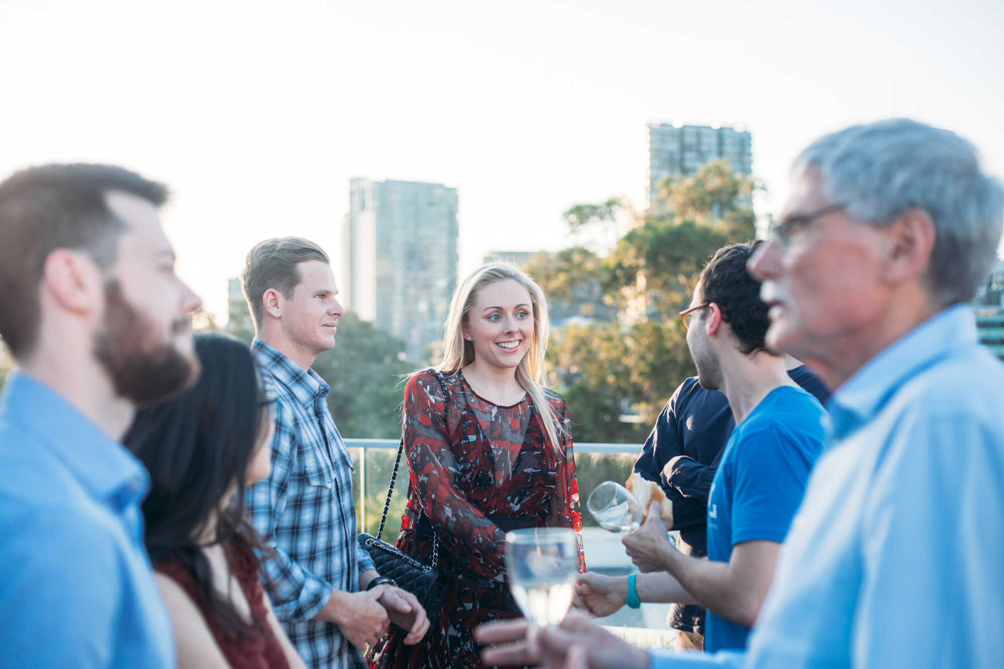 Snappr team networking event at sunset on a rooftop with city skyline in the background