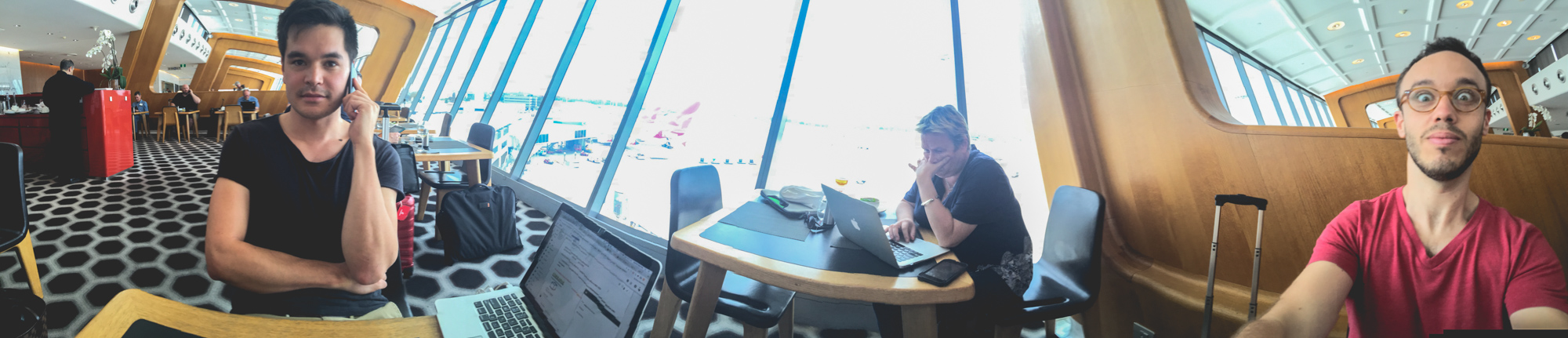 Panoramic photo of Snappr founders working on laptops at the Qantas business lounge before flight to San Francisco
