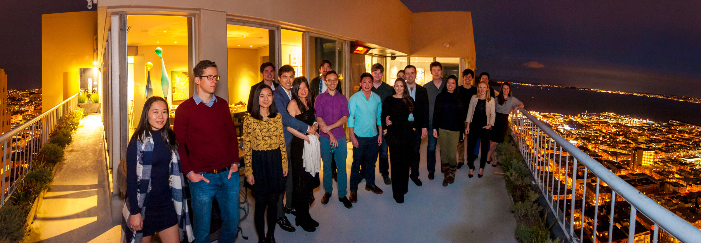 Snappr team group photo on a high-rise rooftop balcony at night with San Francisco city lights