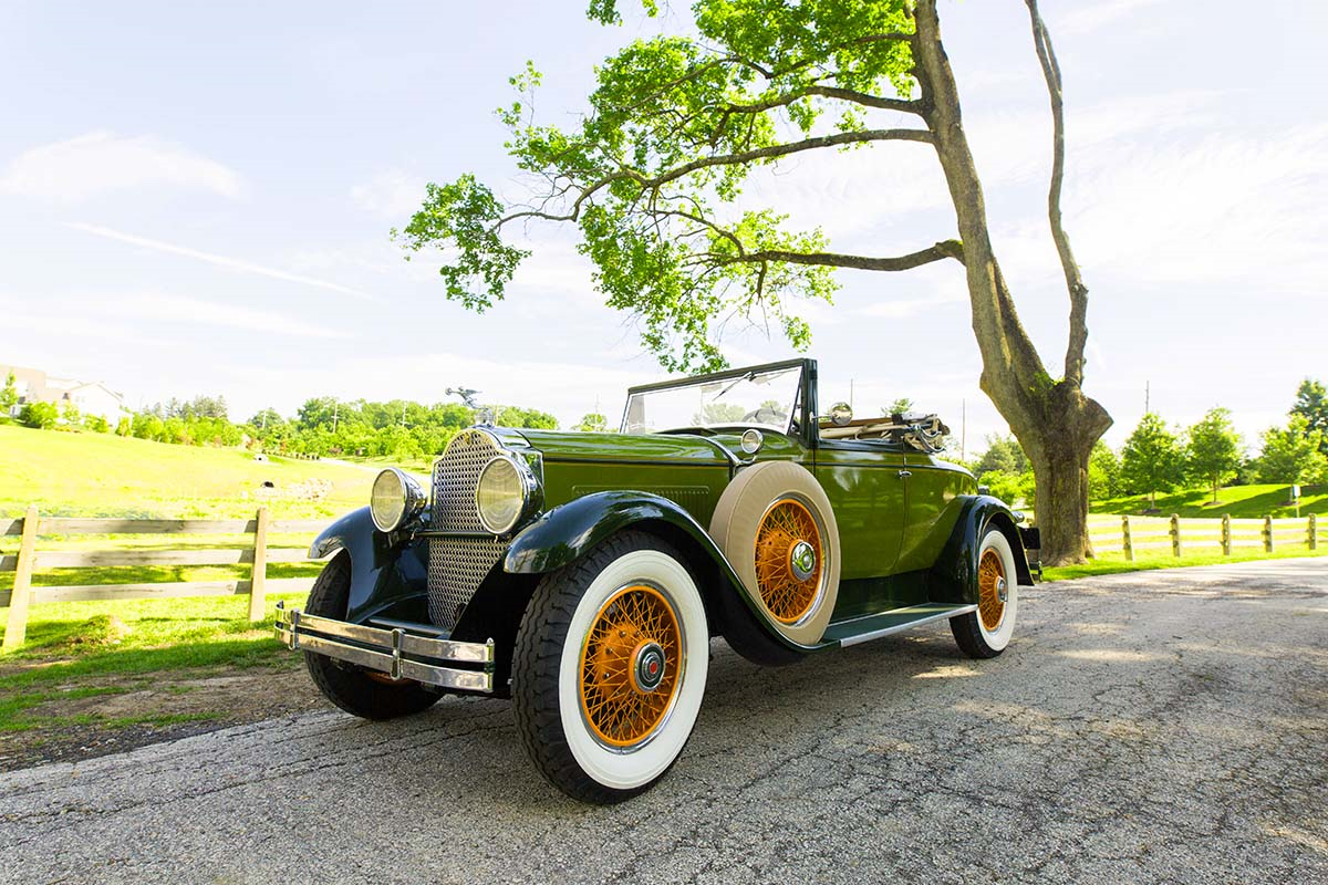 Classic green vintage convertible with white-wall tires parked outdoors — professional automotive photography for online car buying