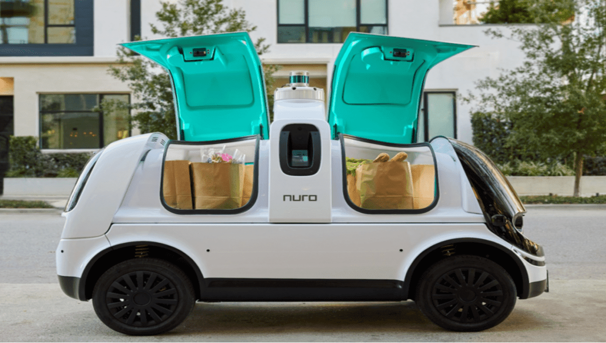 Nuro autonomous delivery vehicle with open cargo doors parked on a suburban street — self-driving food delivery technology