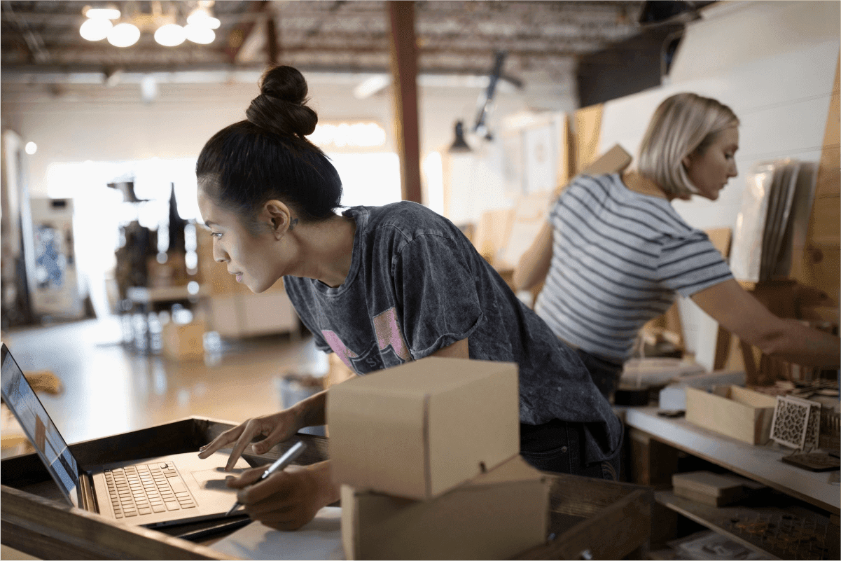 Two retail employees packing orders in a fulfilment warehouse — post on how retailers are thriving post-COVID