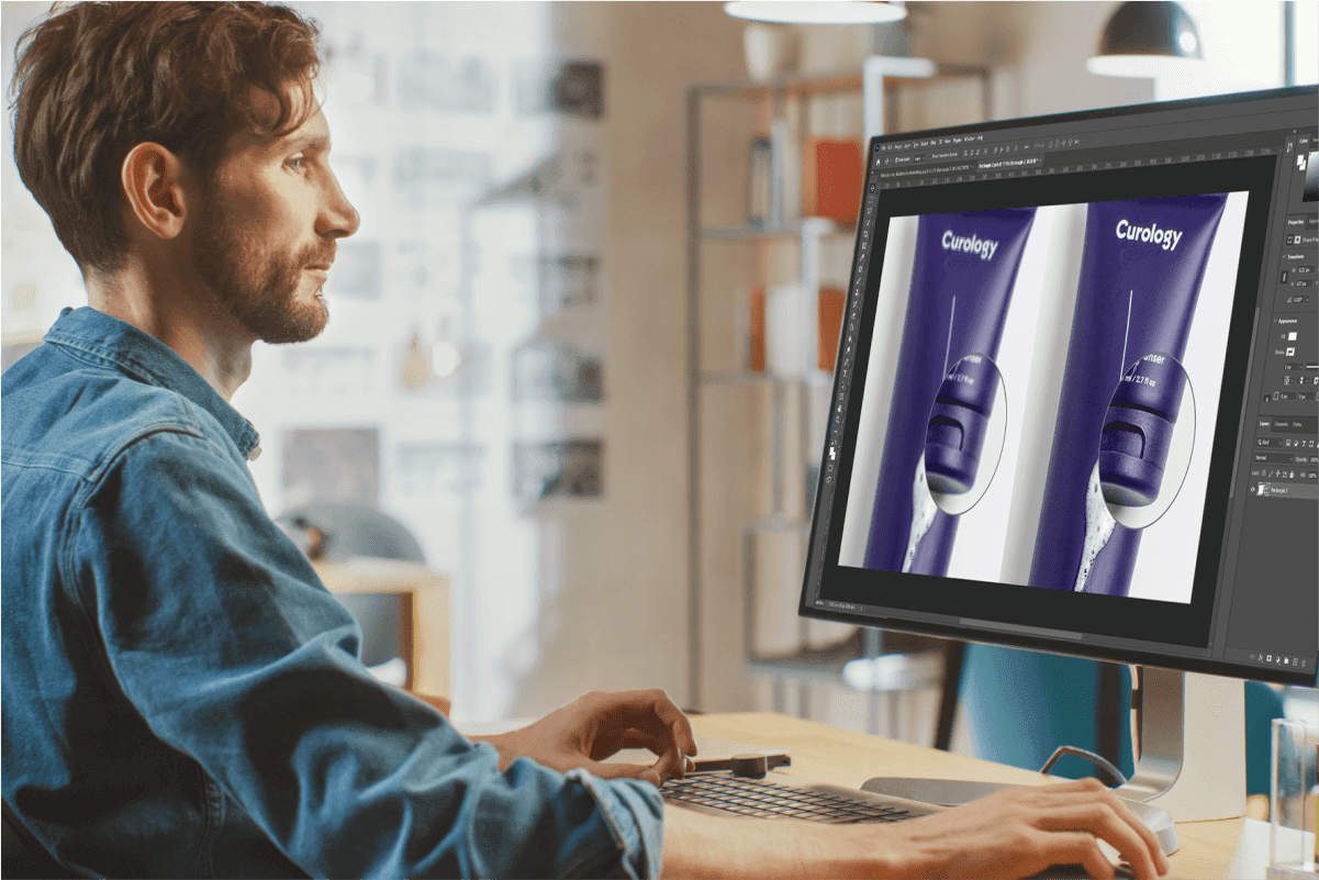 Designer editing product packaging photos on a desktop monitor, showing post-COVID retail digital workflow
