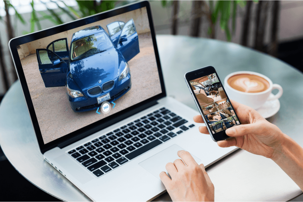 Person browsing a used car listing on laptop and phone — online auto auction site features buyers want
