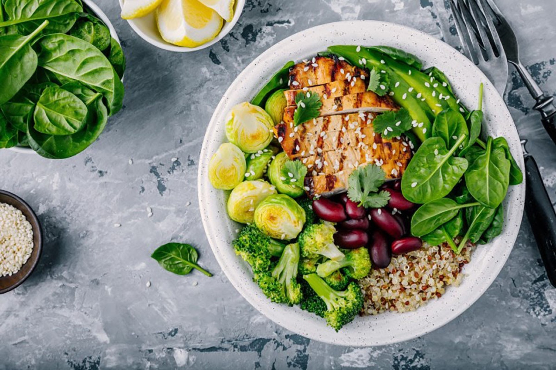 Overhead view of a healthy grain bowl with grilled chicken, broccoli, spinach, and kidney beans — promoting nutritious menu alternatives to counter weight gain