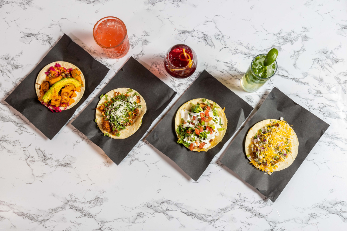Overhead flat lay of four street tacos with cocktails on a marble surface at Verde — Snappr food photography May 2021