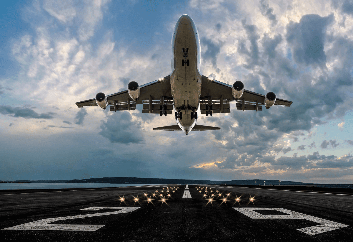 Large commercial aircraft taking off from a runway at dusk, symbolizing the incoming vacation travel boom for hospitality businesses
