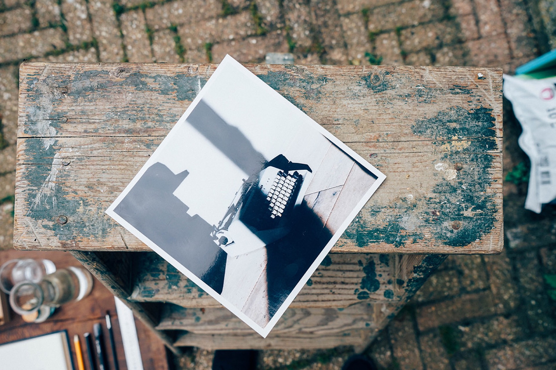 Black-and-white printed photograph resting on a weathered wooden table outdoors, showing why printing your photographs brings life to your space
