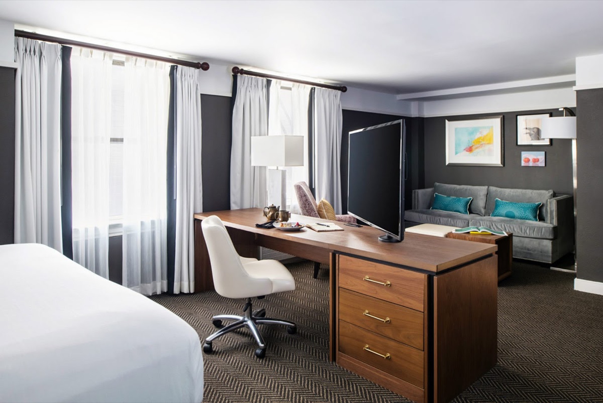 The Commonwealth Richmond hotel room with large work desk, flat-screen TV, and sofa — professional photography for business travelers
