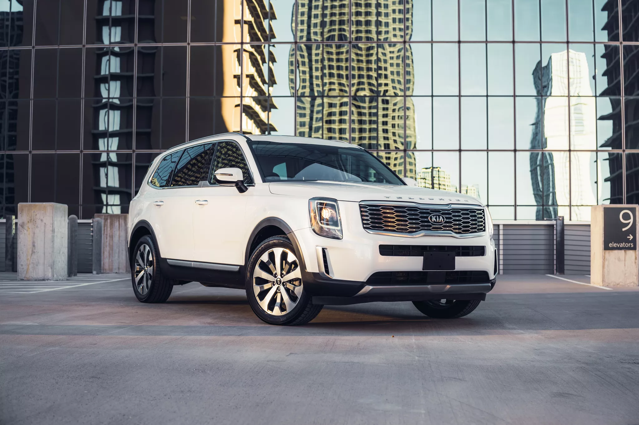 White Kia Telluride SUV parked in urban garage showcasing professional auto photography composition.