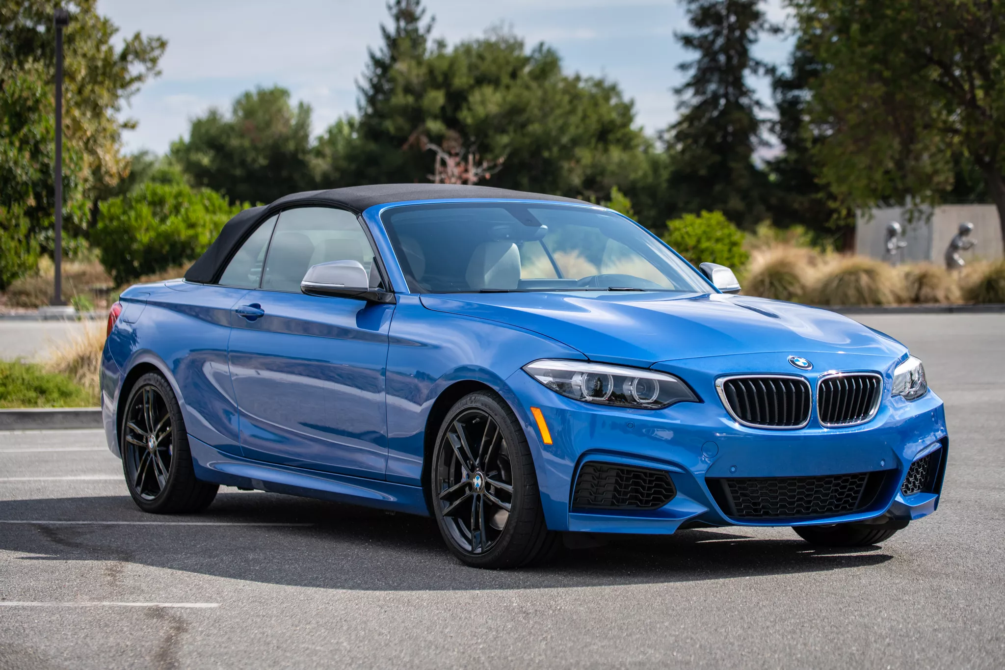 Blue BMW M240i convertible parked outdoors demonstrating professional auto photography techniques.