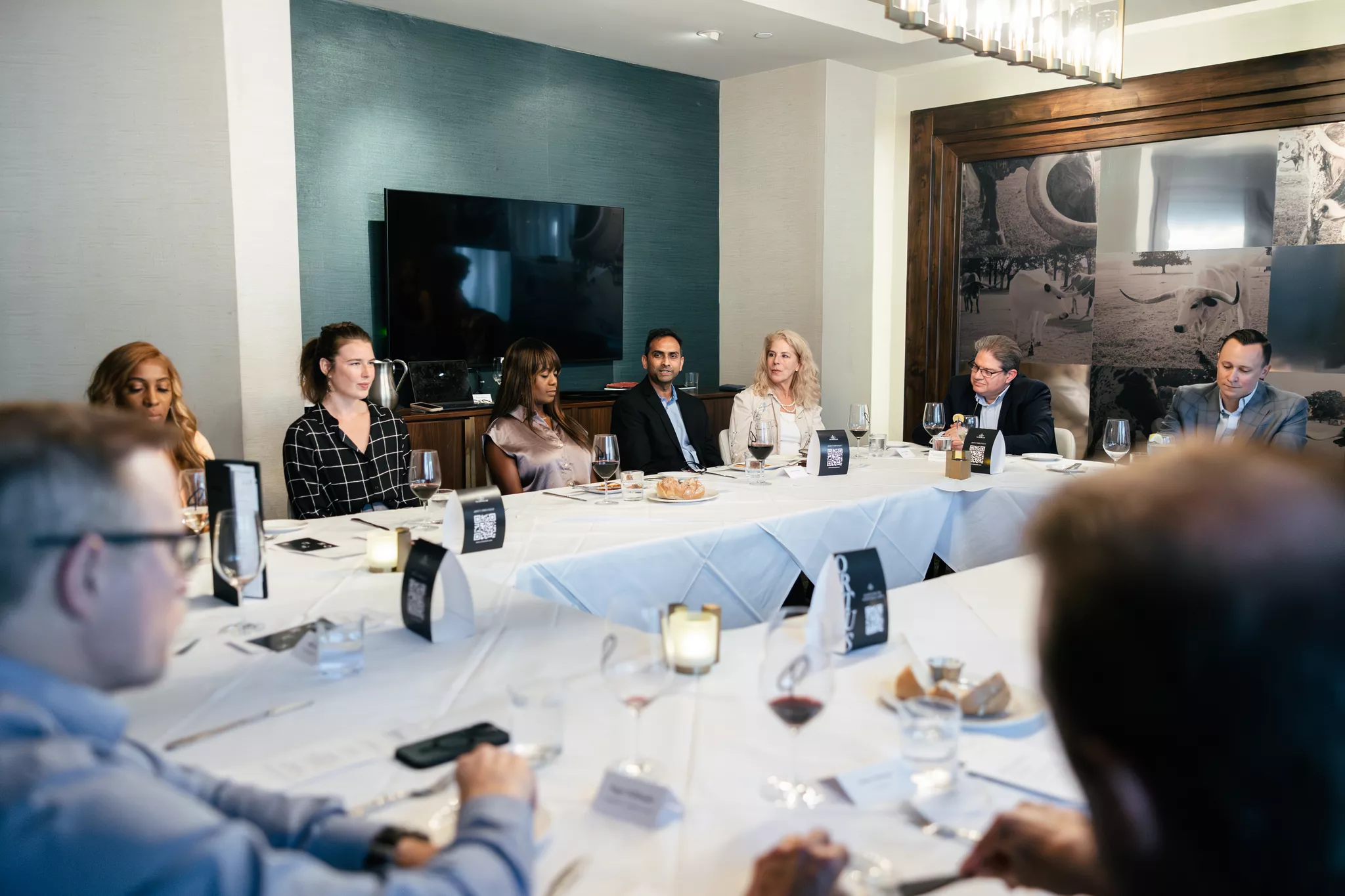 Executive networking dinner around a long banquet table at a corporate event