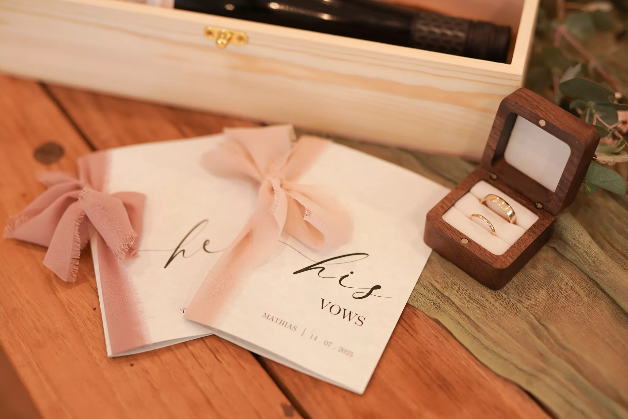 Detail-shot styling a wedding photographer captures: his and hers vows beside gold bands.