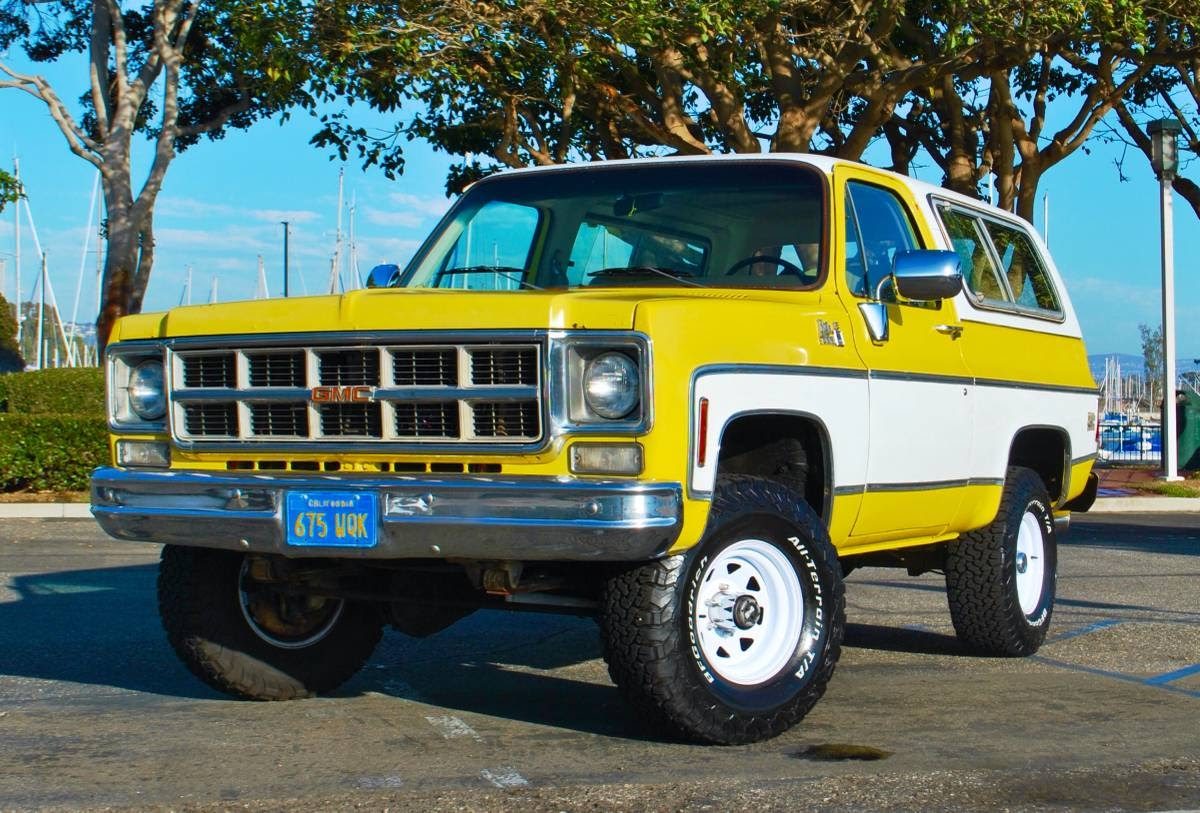 Vintage yellow and white GMC Jimmy parked near a marina on Craigslist