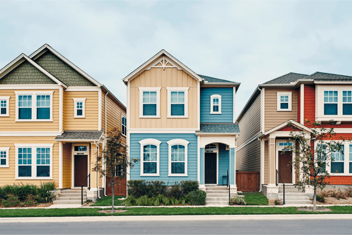 Row of colorful painted houses in yellow blue and red showing neighborhood exterior paint choices