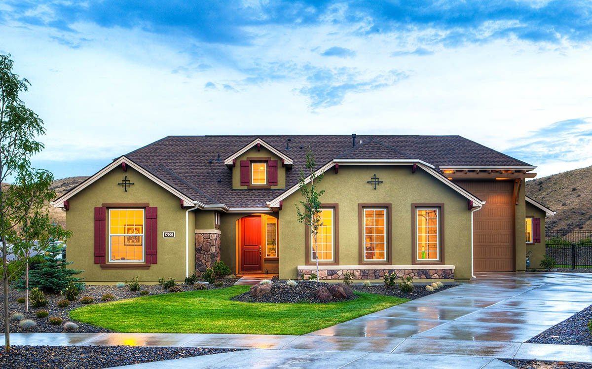 Twilight exterior of a ranch-style home with warm interior lighting, manicured lawn, and stone accents showcasing compelling real estate listing photography