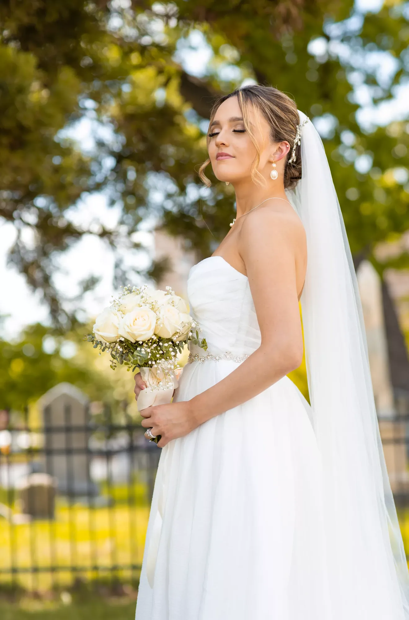 Bridal portrait by a quality wedding photographer, veil and white rose bouquet.