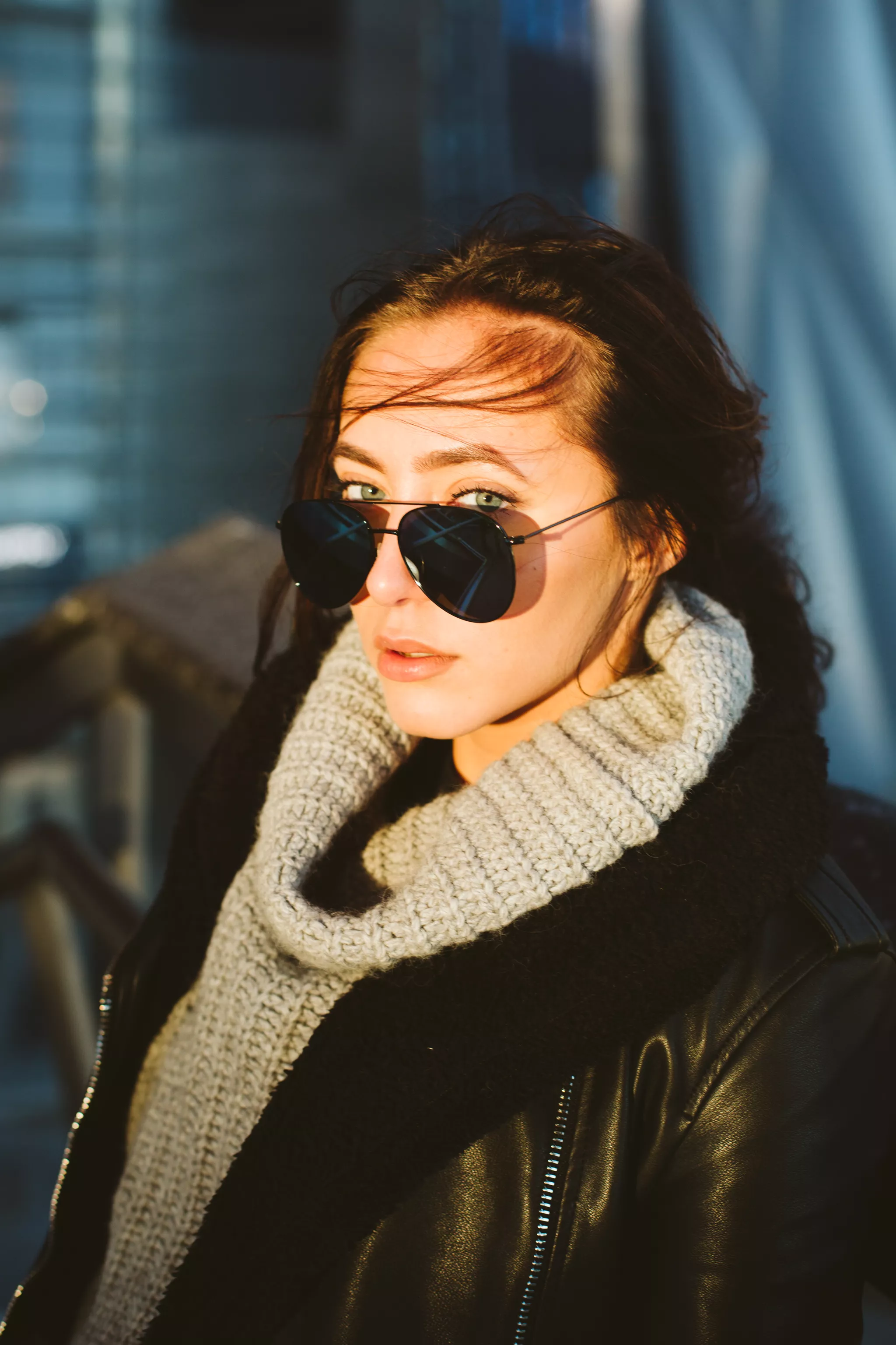 Lifestyle editorial portrait of a woman in a leather jacket in warm side light.