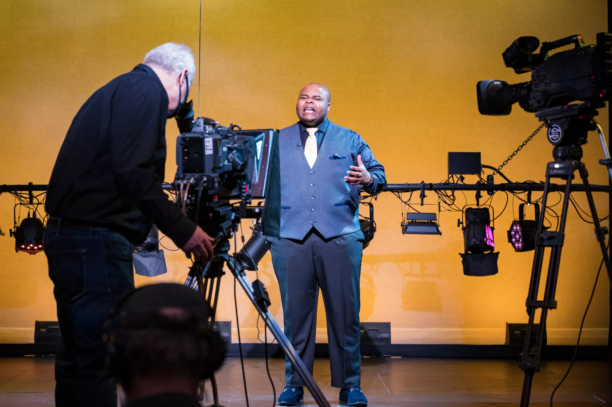 Gimbal-mounted video production service camera recording a speaker at a busy event.