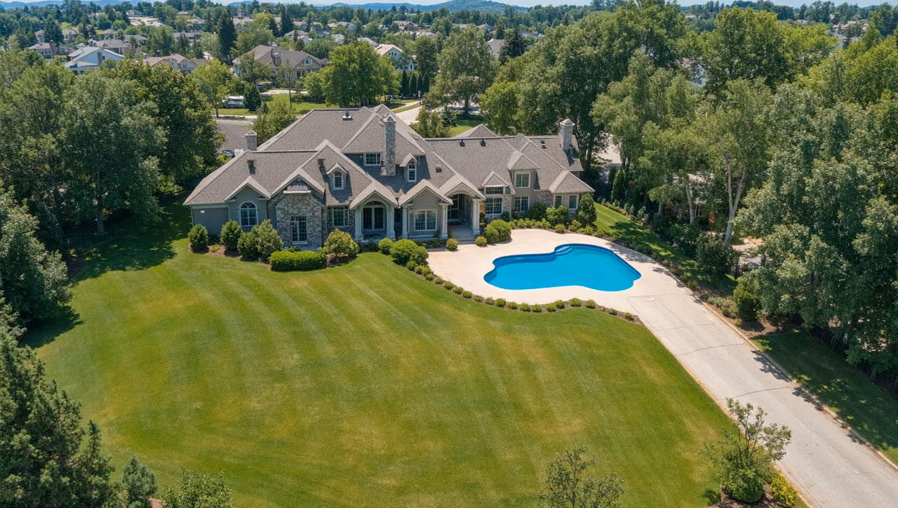 Drone real estate photography showing aerial view of a residential property with pool and landscaping