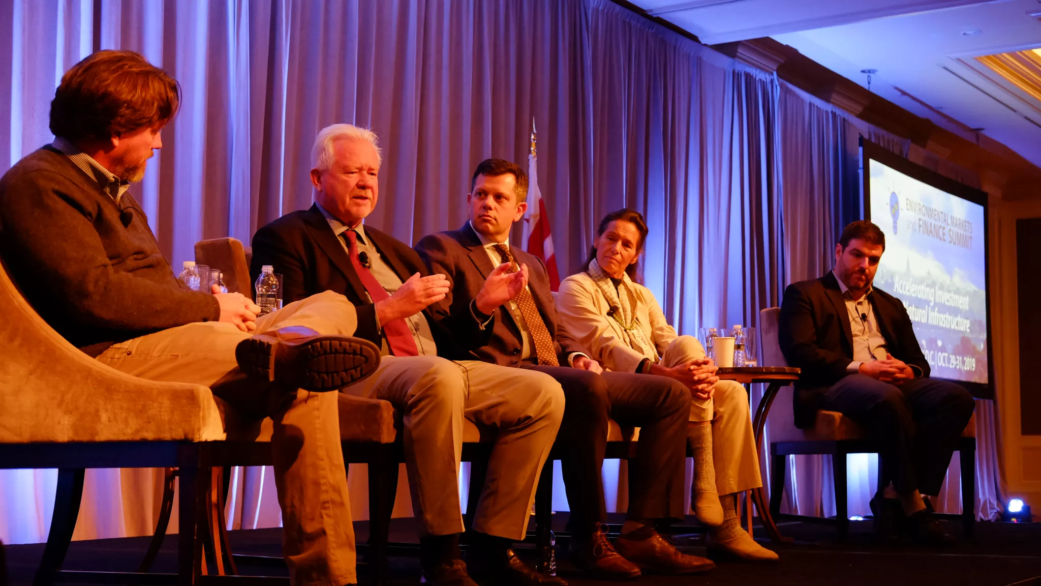 Five panelists seated on stage mid-discussion, captured by a convention photographer.