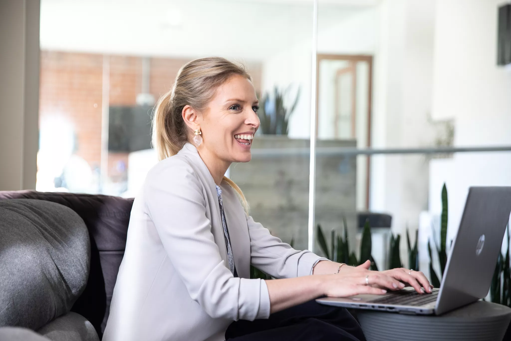 mployee laughing mid-conversation with a laptop, from a candid company photoshoot.