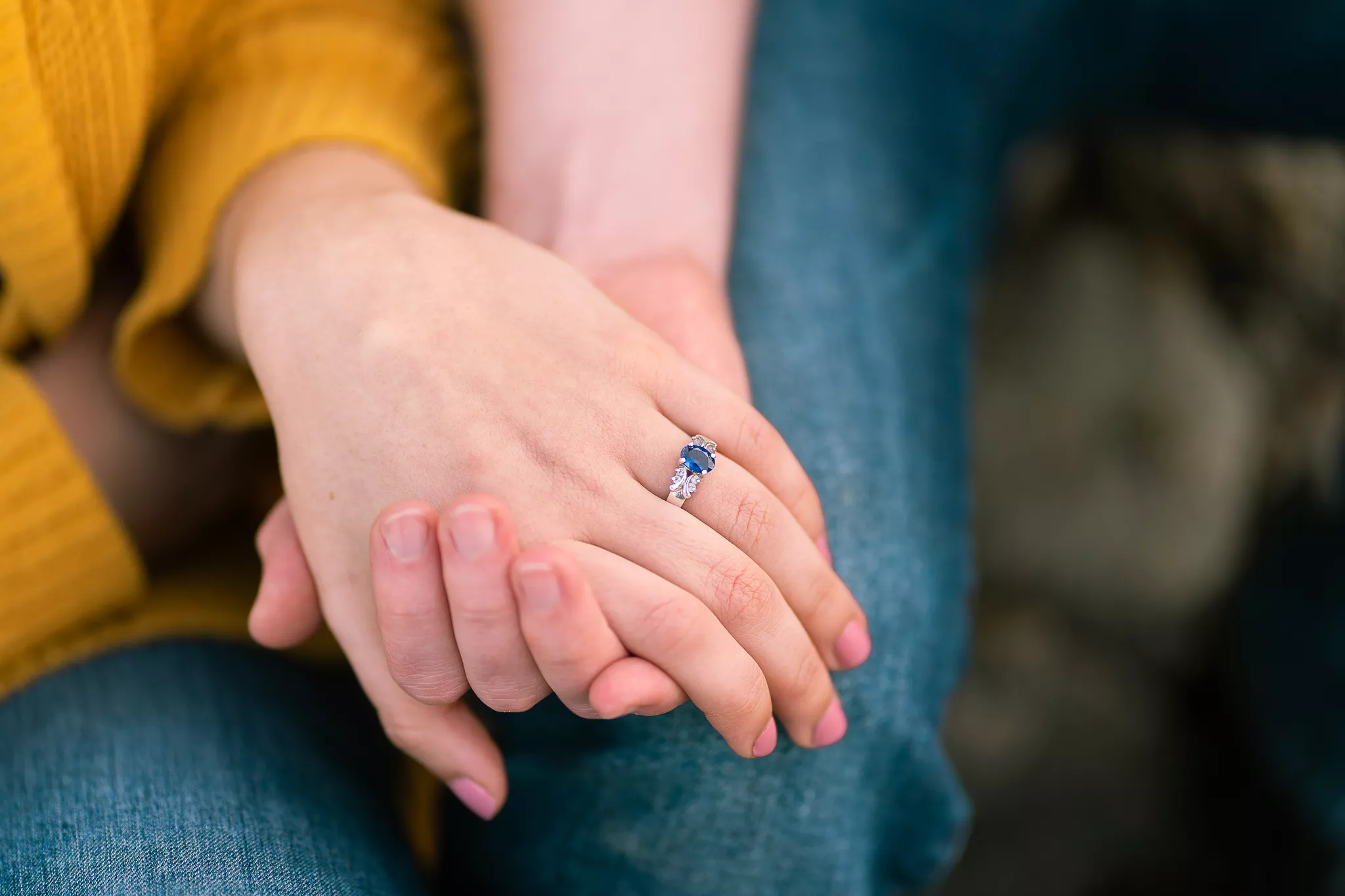 Engagement photo poses for the ring shot — one hand draped over the other, sapphire ring in focus