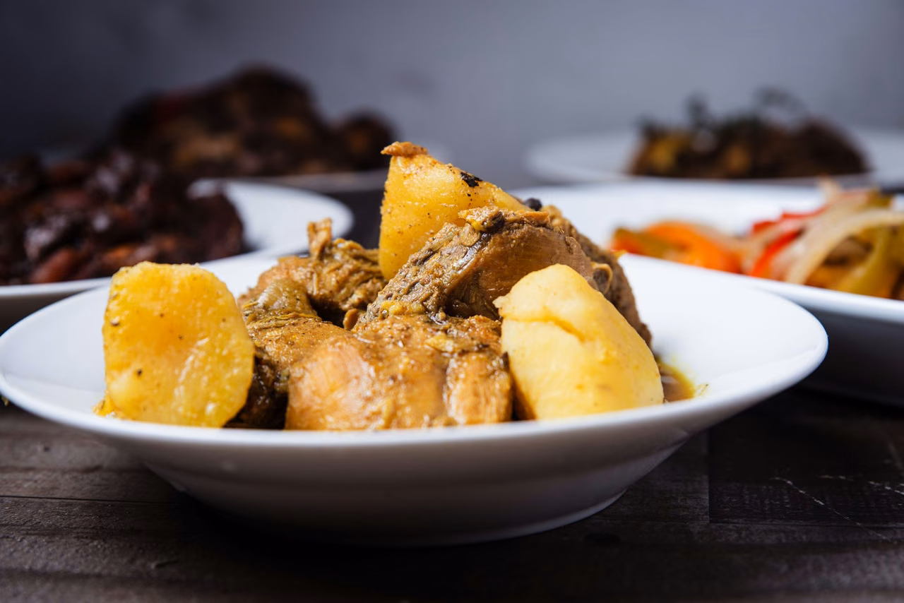 Caribbean stew with chicken and yellow yam in a white bowl from a food photography package
