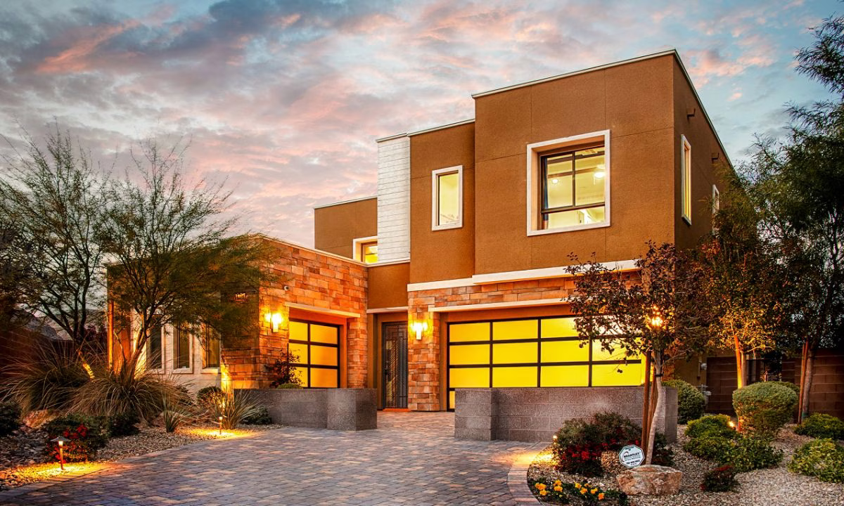 Professional real estate photo of a modern two-story home exterior at dusk with warm lighting
