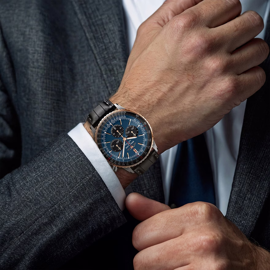 Man in a suit wearing a luxury Breitling chronograph watch for a lifestyle brand campaign.