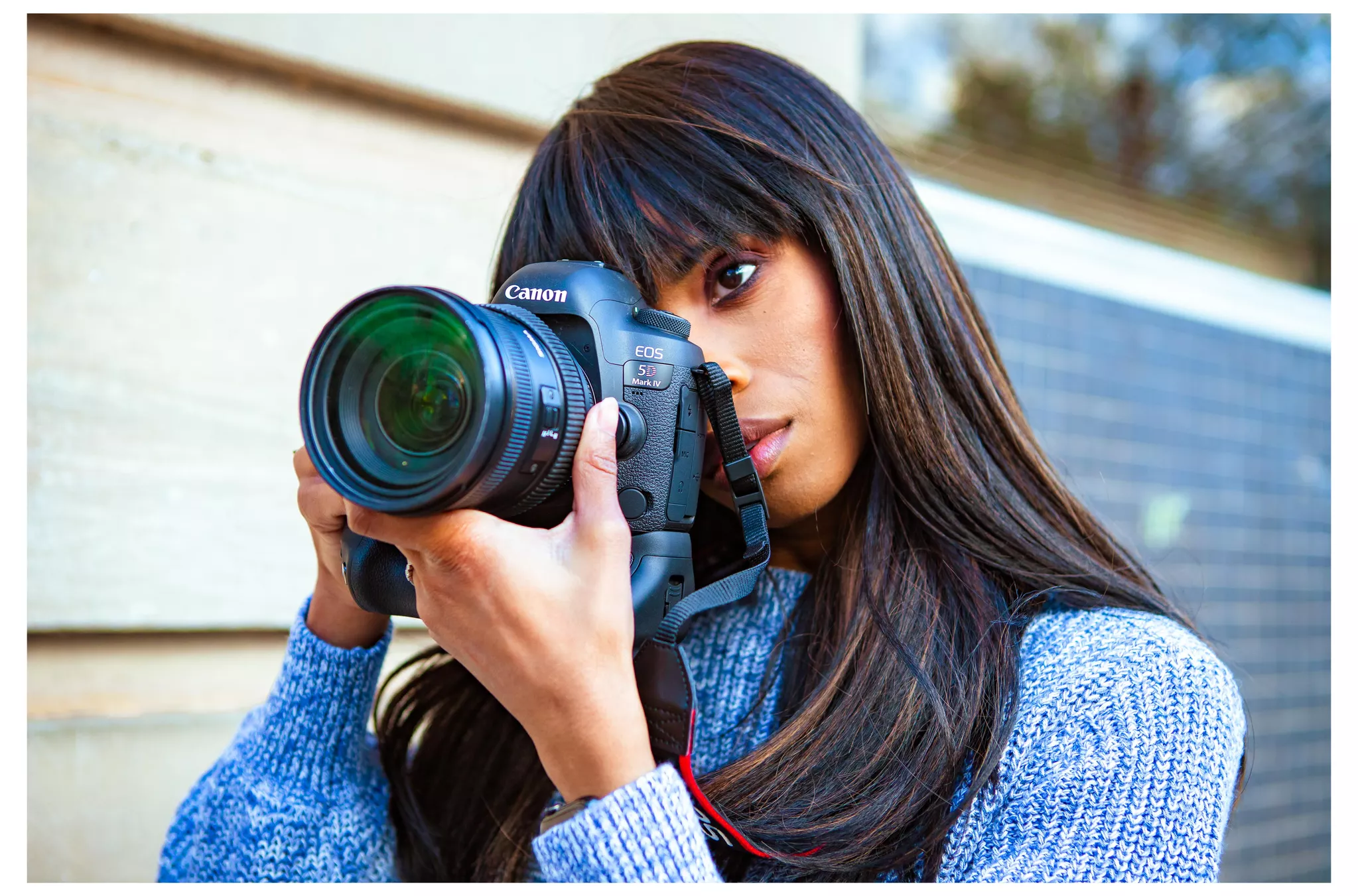 Professional photographer in a blue sweater shooting with a Canon EOS 5D Mark IV