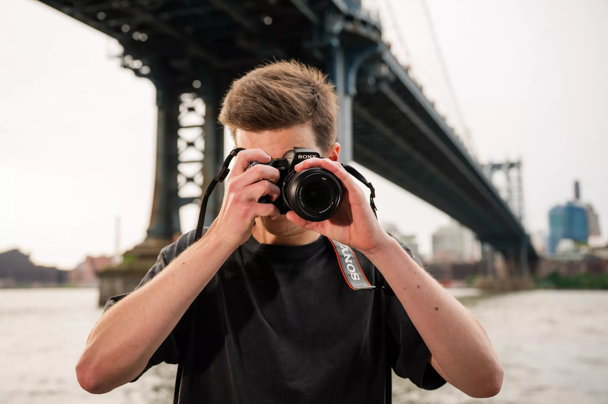 Photographer shooting with a Sony DSLR under the Manhattan Bridge on the waterfront