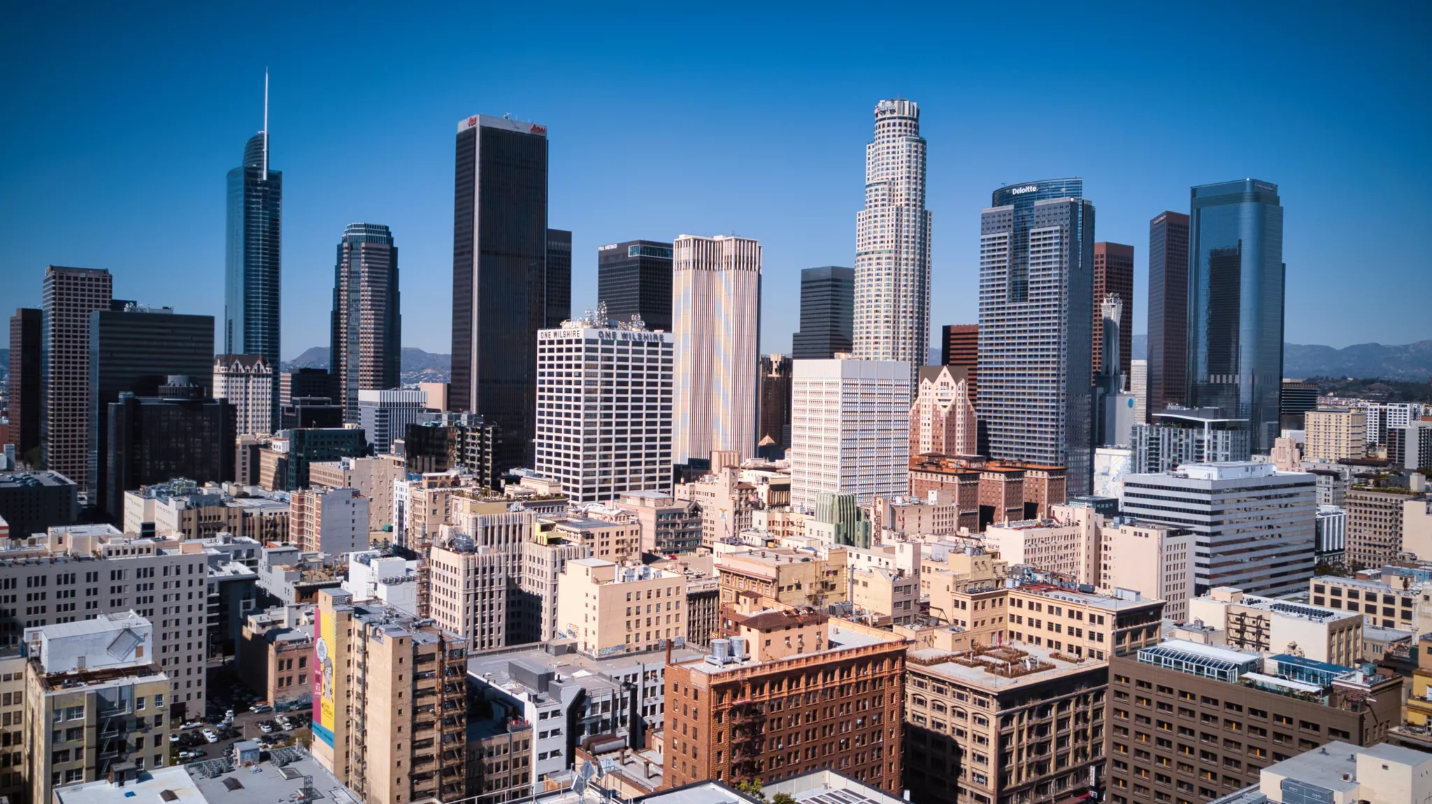 Elevated architectural photography of a dense downtown Los Angeles skyline under a clear sky