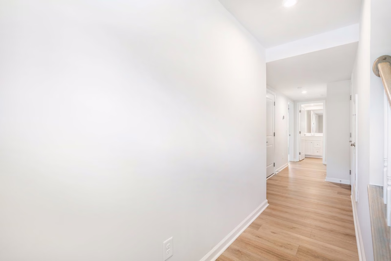 Empty white room with hardwood flooring, the standard starting point for AI virtual staging in real estate