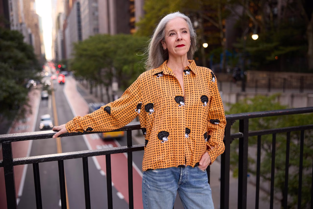 Model wearing a patterned jacket on a city street, an example of apparel photographed in use rather than as a flat packshot