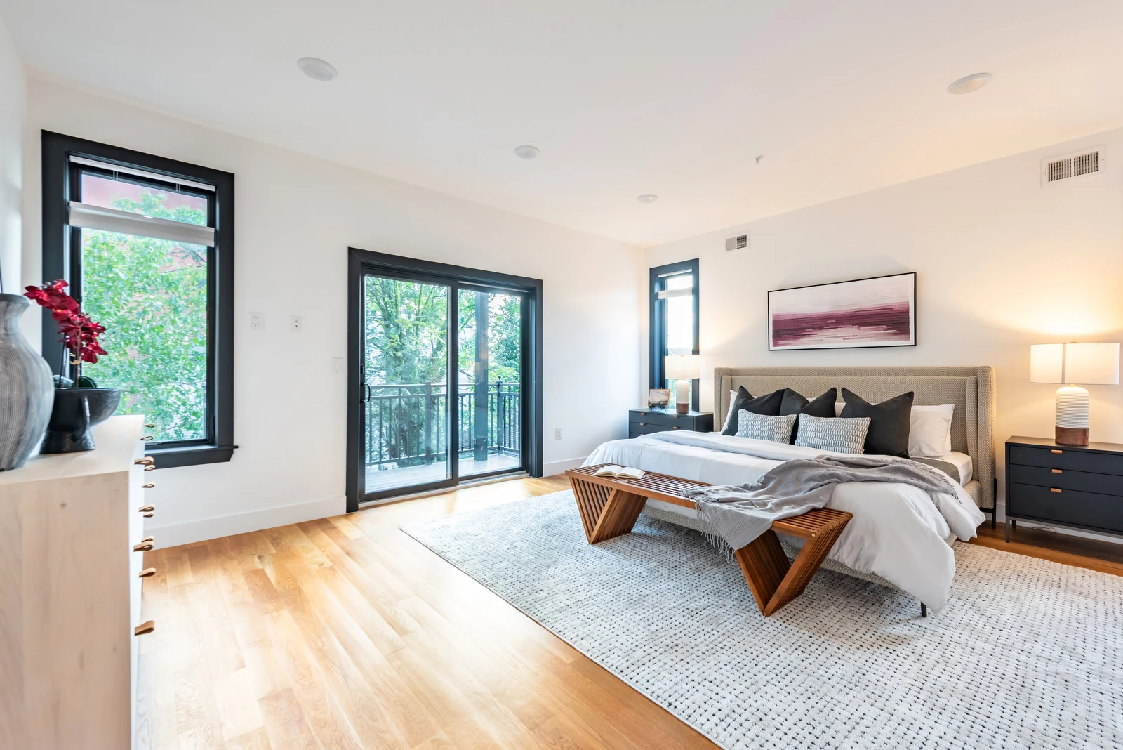 Bright bedroom with lamps on and balcony doors open, meeting Booking.com photo requirements
