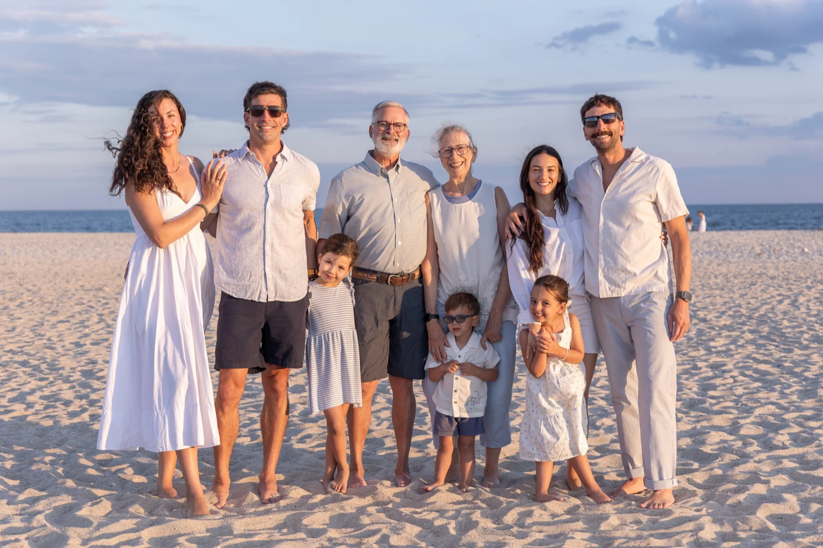 Family photo outfit ideas in white, cream, gray and navy for a big family on the beach